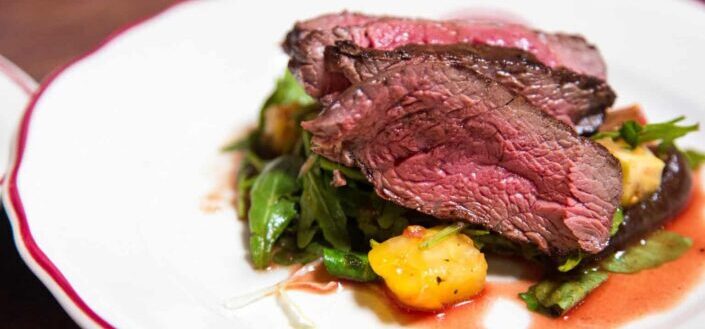 Medium Rare Sliced Steak on White Ceramic Plate