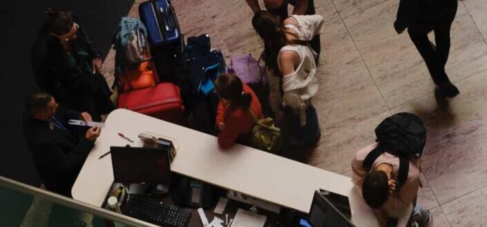 Crowd of People Waiting at the Hotel Reception Desk