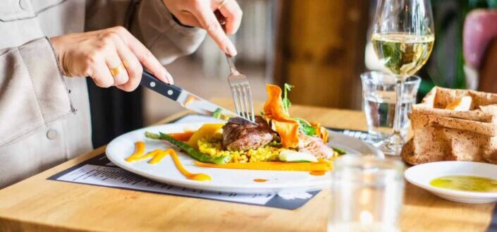 Person Using Knives and Fork to Eat