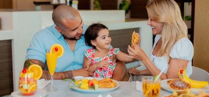 Parents and Their Child Happily Eating Together